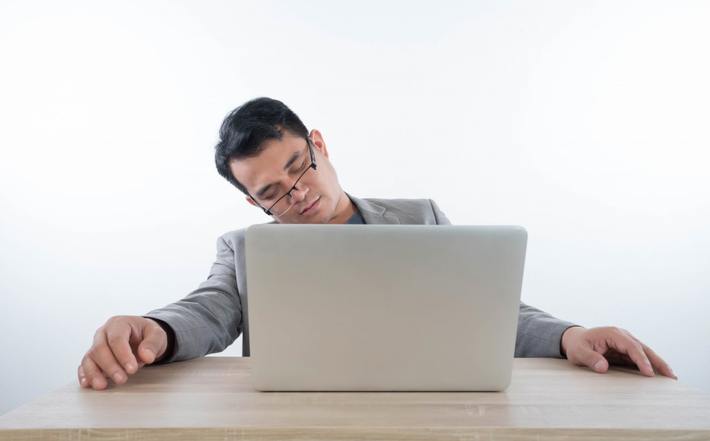 Man sleeping in the front of his laptop