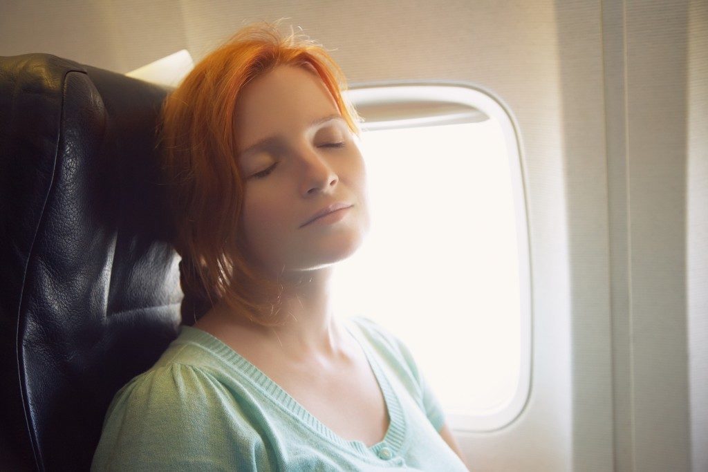 Sleeping woman in the chair on board the aircraft