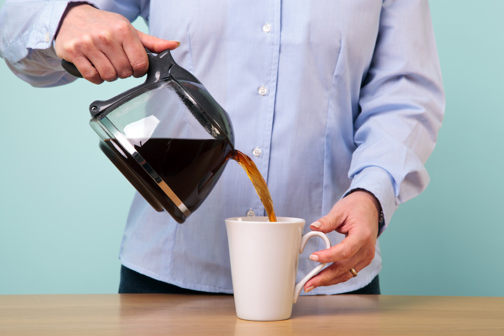 a man pouring coffee on his mug