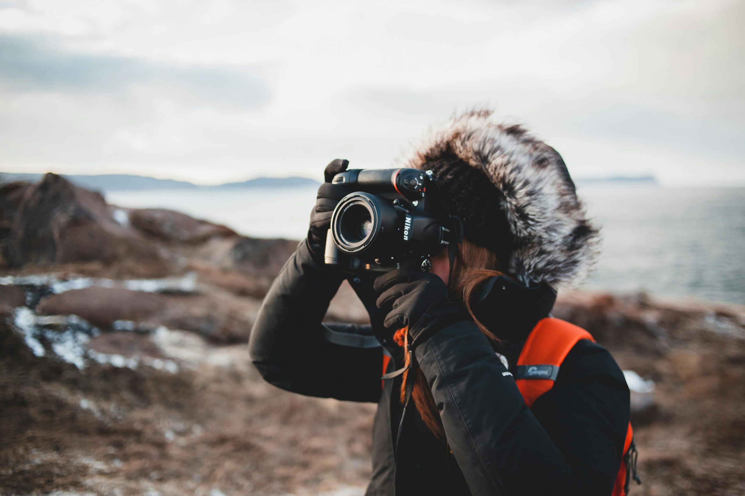 woman in heavy winter clothing taking photos